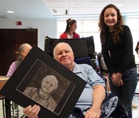 student and man smiling with picture