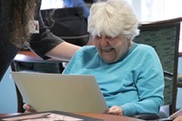 woman smiling looking at drawing