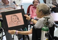 woman smiling looking at drawing of herself