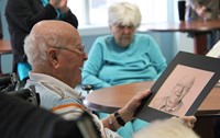 man looking at drawing of himself