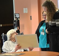 student and resident smiling at drawing