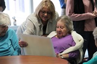 nursing home employee and resident looking at drawing