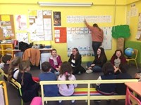 high school students talking about the alphabet with elementary students