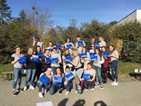 students outside holding blue boxes