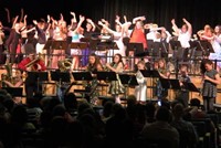 students playing instruments with students dancing in background