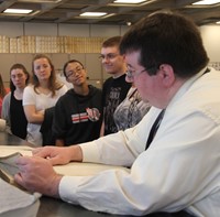 people looking at book up close