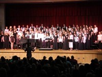 medium shot of high school and middle school choirs singing together