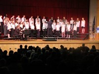 students singing with painting on stage