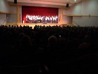 wide shot of auditorium with chorus singing