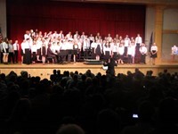 students singing with new painting on stage