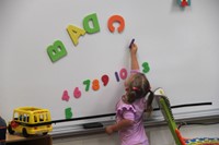 student playing with magnet letter