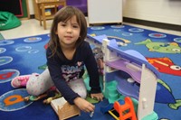 student playing with toy house