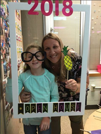 adult and student with photo props at open house