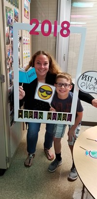 one adult and student with photo props at open house