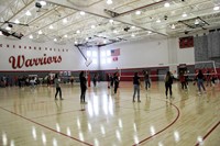 students playing volleyball in gymnasium