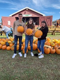 Chenango Valley French Exchange students holding pumpkins