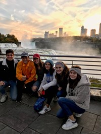 students sitting next to niagra falls