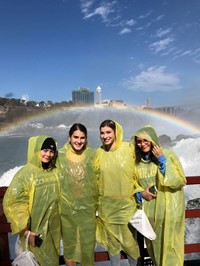 students standing next to rainbow at niagra falls