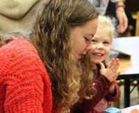 french student and elementary student taking part in activity