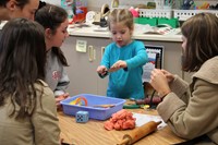 pre k student showing french students play doh activity