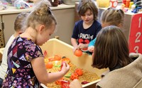 french student taking part in activity with pre k students