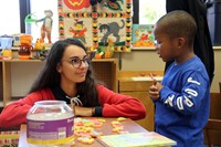 french student and pre k student taking part in activity