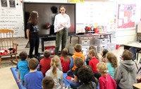 french students reading to elementary class