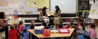 french students reading to elementary class