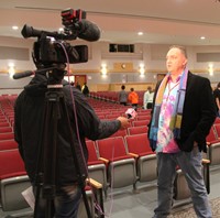 honoree adam cornell speaking to news reporter