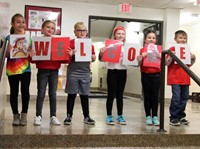 students holding up a welcome sign