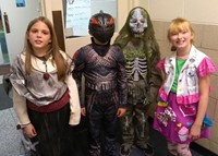 four students in costumes