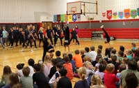 middle school students doing flips during performance