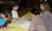 two students and two adults at activity station