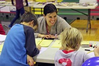 two students and adult at activity station