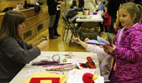 students and adults interacting at activity station