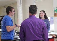 two students talking to teacher about project