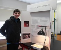 student standing next to project