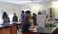 wide shot of students presenting projects in classroom