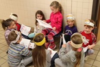 first grade student reading to peers