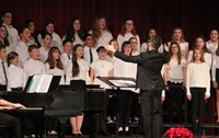 medium shot of seventh and eighth grade chorus members singing