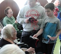 two students handing out ornaments