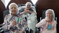 residents holding up ornaments smiling