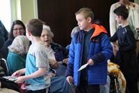 wide shot of chorus performing for residents