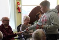 student handing resident ornament