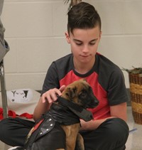 student petting puppy