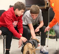 two students petting puppy
