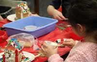 student decorating gingerbread house