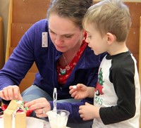 two people decorating gingerbread house