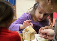 student decorating gingerbread house