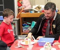 two people creating a gingerbread house